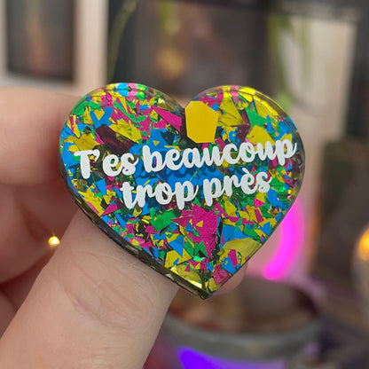 [CONTRÔLE TECHNIQUE] Broche "T'es beaucoup trop près" en acrylique transparente avec des éclats de confettis jaunes, verts, bleus et roses