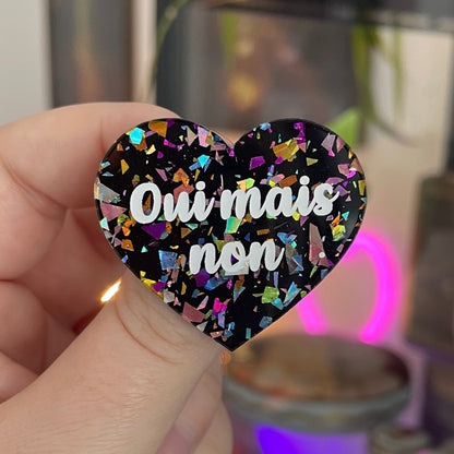 [CONTRÔLE TECHNIQUE] Broche "Oui mais non" en acrylique noire avec des éclats de confettis multicolores