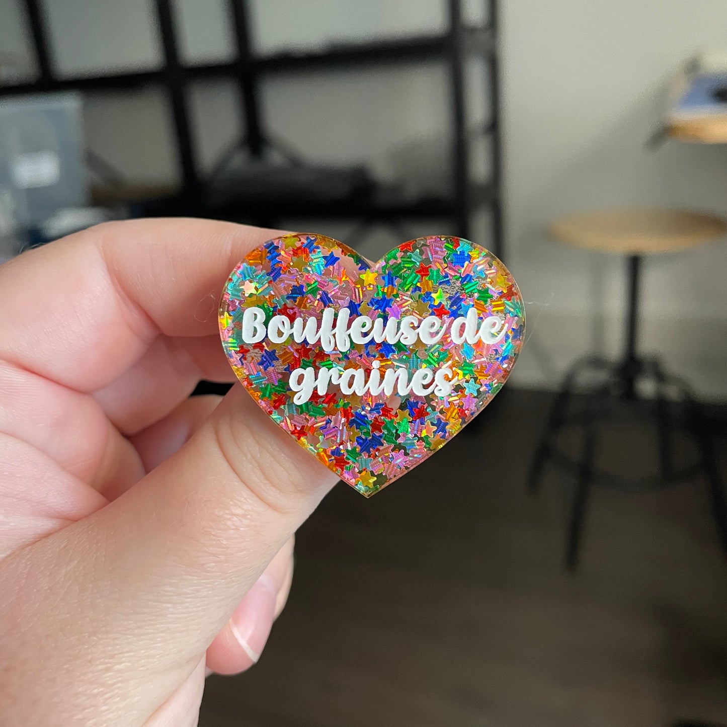 [CONTRÔLE TECHNIQUE] Broche "Bouffeuse de graines" en acrylique semi transparente avec des confettis étoiles multicolores