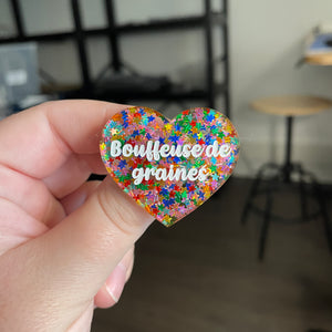 [CONTRÔLE TECHNIQUE] Broche "Bouffeuse de graines" en acrylique semi transparente avec des confettis étoiles multicolores