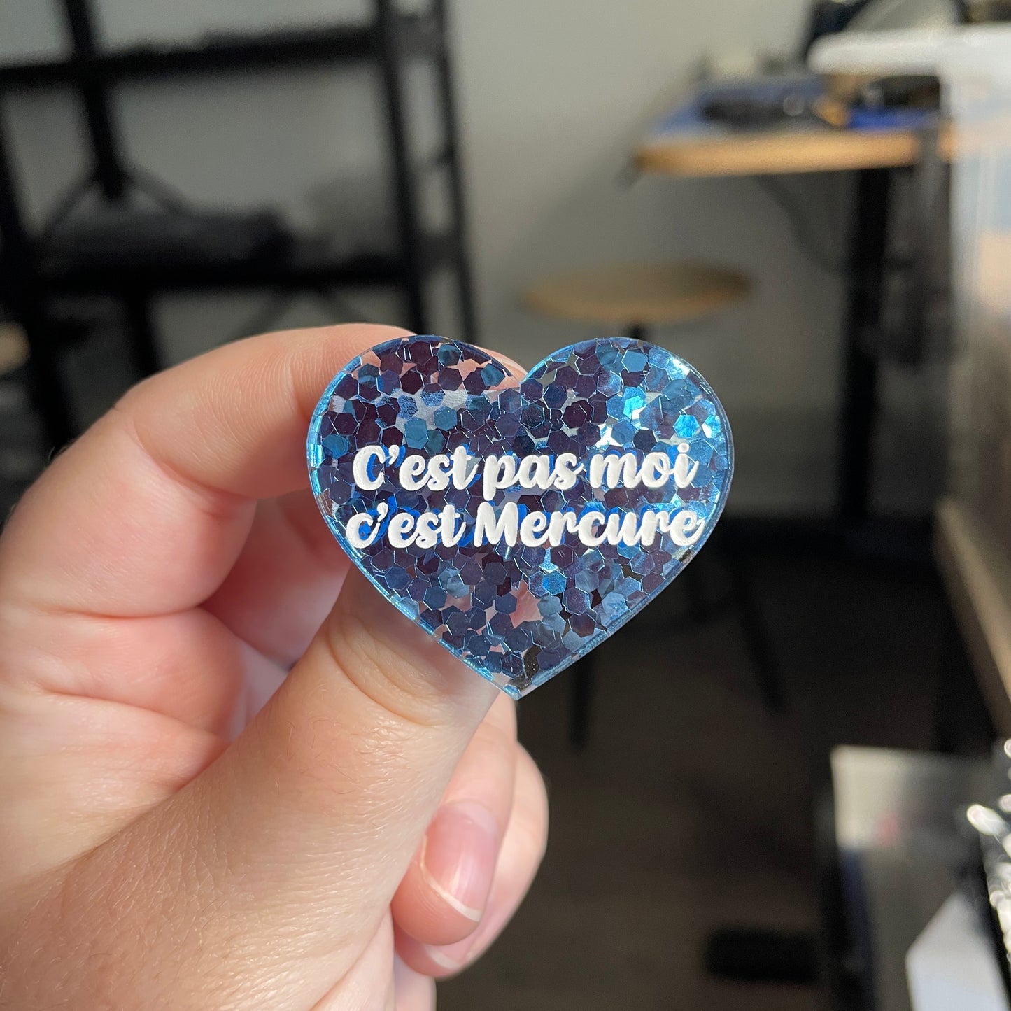 [CONTRÔLE TECHNIQUE] Broche "C'est pas moi c'est Mercure" en acrylique semi transparente avec des confettis bleus