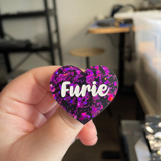 [CONTRÔLE TECHNIQUE] Broche "Furie" en acrylique noire avec des éclats de confettis violets