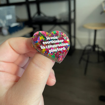 [CONTRÔLE TECHNIQUE] Broche "Je vais overthinker la conversation plus tard" en acrylique transparente avec des confettis roses et multicolores