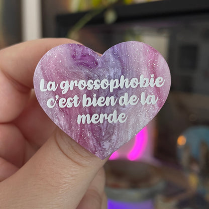 Broche "La grossophobie c'est bien de la merde" en acrylique marbrée violette, rose et blanche à paillettes