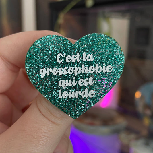 Broche "C'est la grossophobie qui est lourde" en acrylique à paillettes turquoise