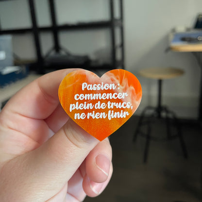 [CONTRÔLE TECHNIQUE] Broche "Passion : commencer plein de trucs, ne rien finir" en acrylique marbrée orange et dorée à paillettes