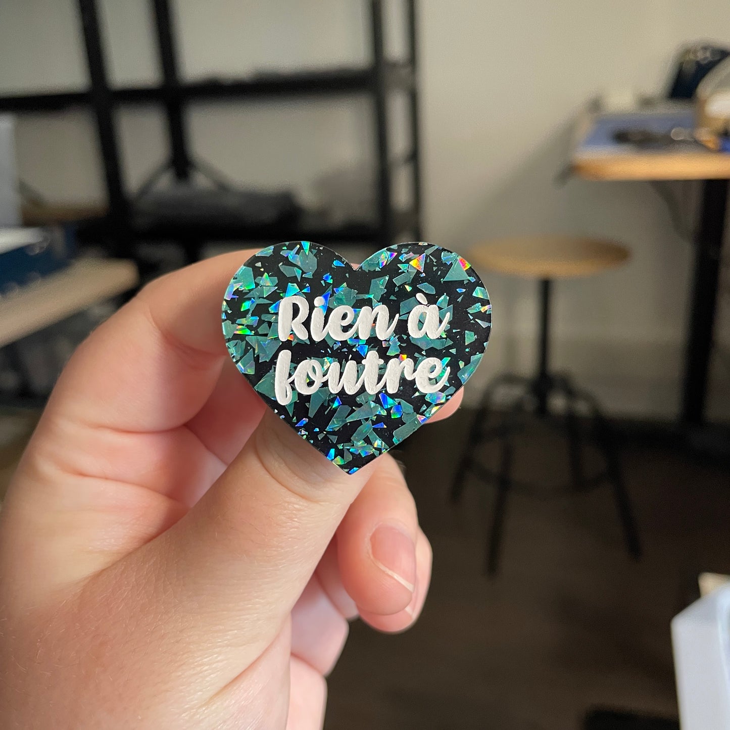 [CONTRÔLE TECHNIQUE] Broche "Rien à foutre" en acrylique noire avec des éclats de confettis turquoise