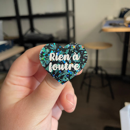 [CONTRÔLE TECHNIQUE] Broche "Rien à foutre" en acrylique noire avec des éclats de confettis turquoise
