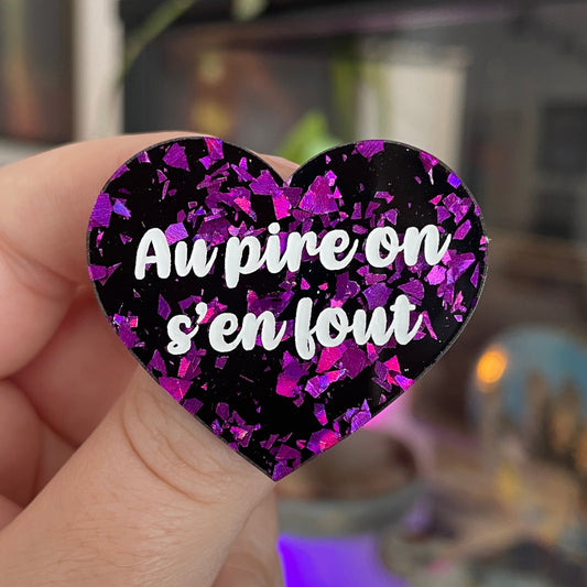 Broche "Au pire on s'en fout" en acrylique noire avec des éclats de confettis violets