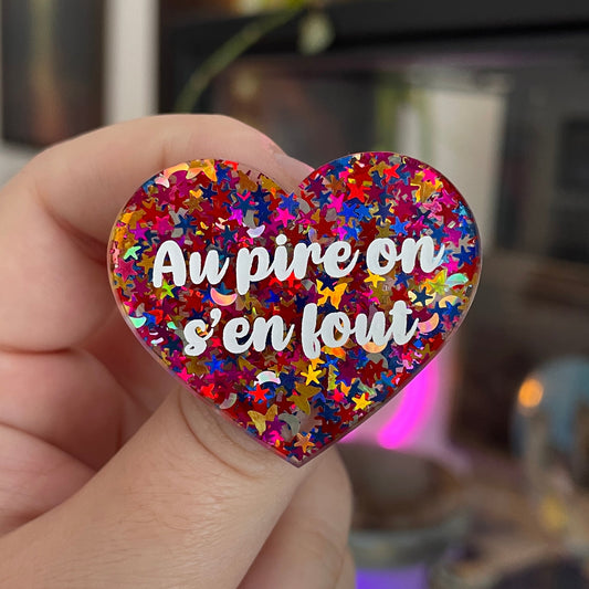 Broche "Au pire on s'en fout" en acrylique semi transparente avec des confettis multicolores