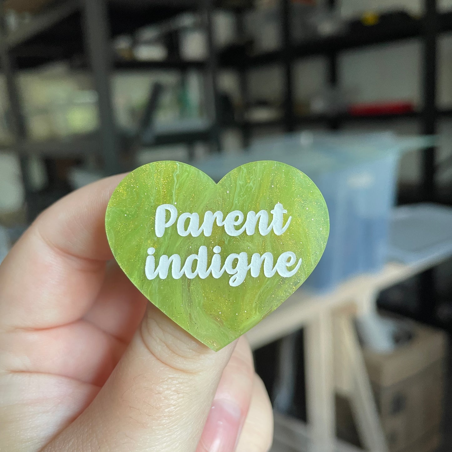 Broche "Parent indigne" en acrylique marbrée verte et dorée à paillettes