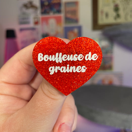 Broche "Bouffeuse de graines" en acrylique à paillettes oranges
