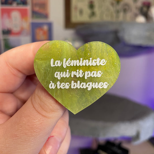 Broche "La féministe qui rit pas à tes blagues" en acrylique marbrée verte et dorée