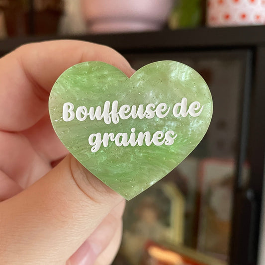 Broche "Bouffeuse de graines" en acrylique marbrée verte à paillettes