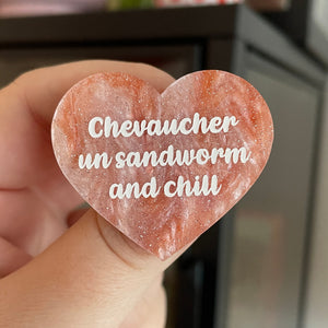 Broche "Chevaucher un sandworm and chill" en acrylique marbrée blanche et orange à paillettes