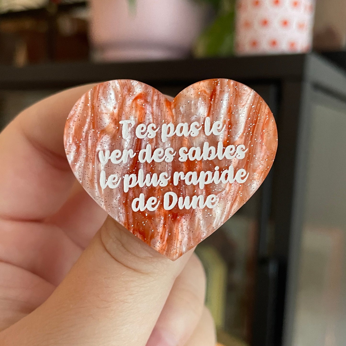 Broche "T'es pas le ver des sables le plus rapide de Dune" en acrylique marbrée blanche et orange à paillettes