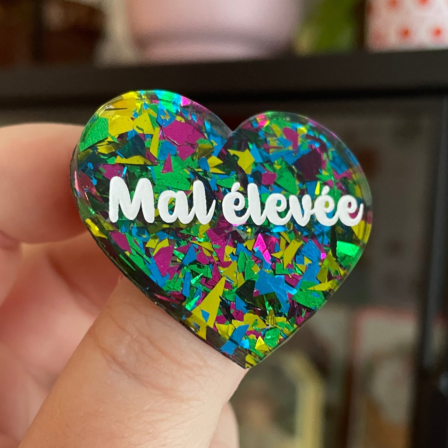 Broche "Mal élevée" en acrylique transparente à gros confettis verts, roses, jaunes et bleus