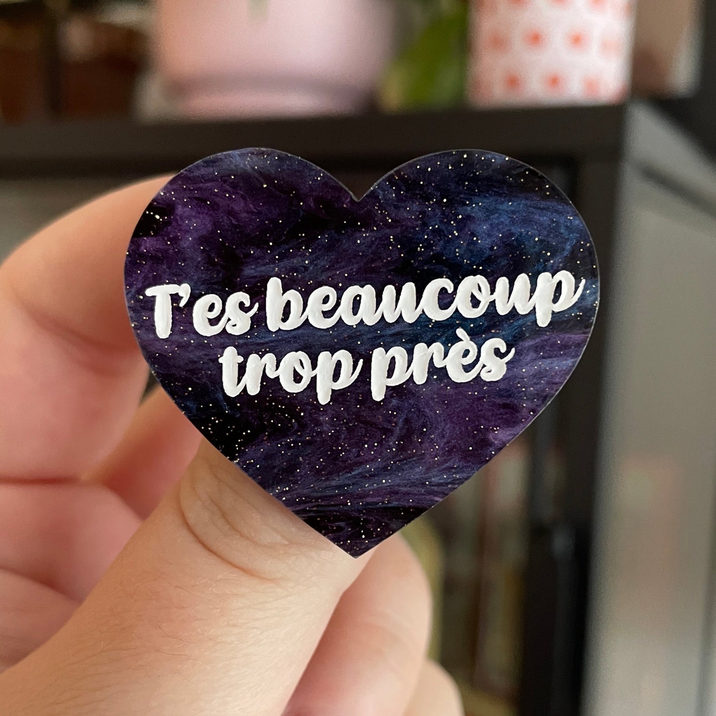Broche "T'es beaucoup trop près" en acrylique marbrée bleue, noire et violette à paillettes