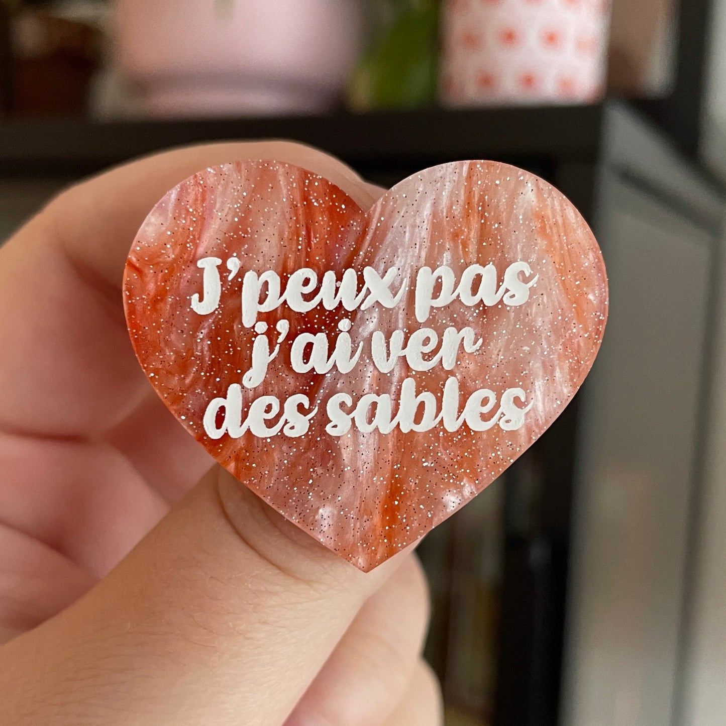 Broche "J'peux pas j'ai ver des sables" en acrylique marbrée blanche et orange à paillettes