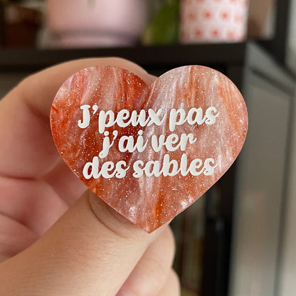 Broche "J'peux pas j'ai ver des sables" en acrylique marbrée blanche et orange à paillettes