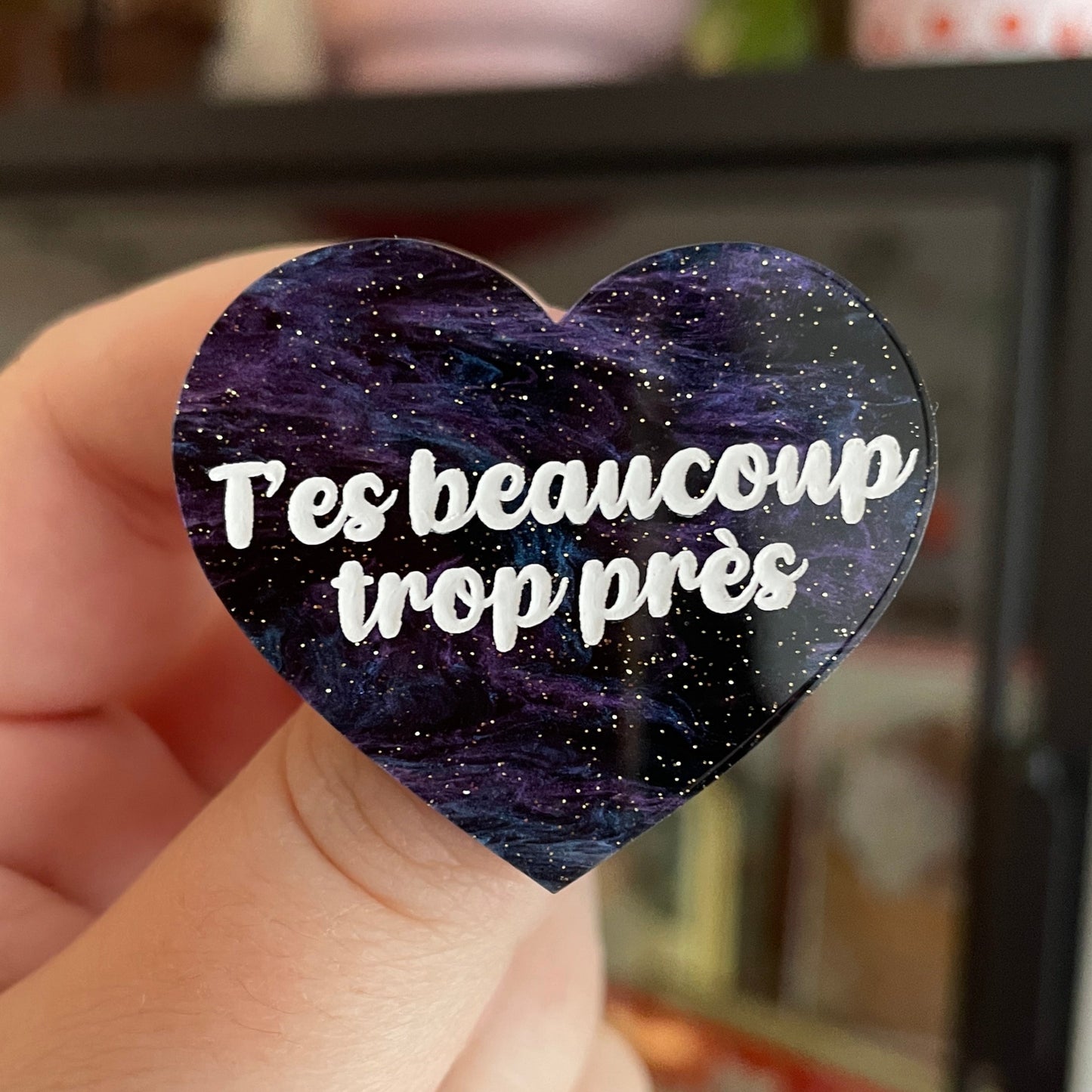 Broche "T'es beaucoup trop près" en acrylique marbrée bleue, noire et violette à paillettes