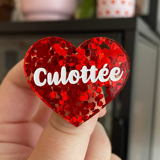 Broche "Culottée" en acrylique semi-transparente avec des confettis rouges
