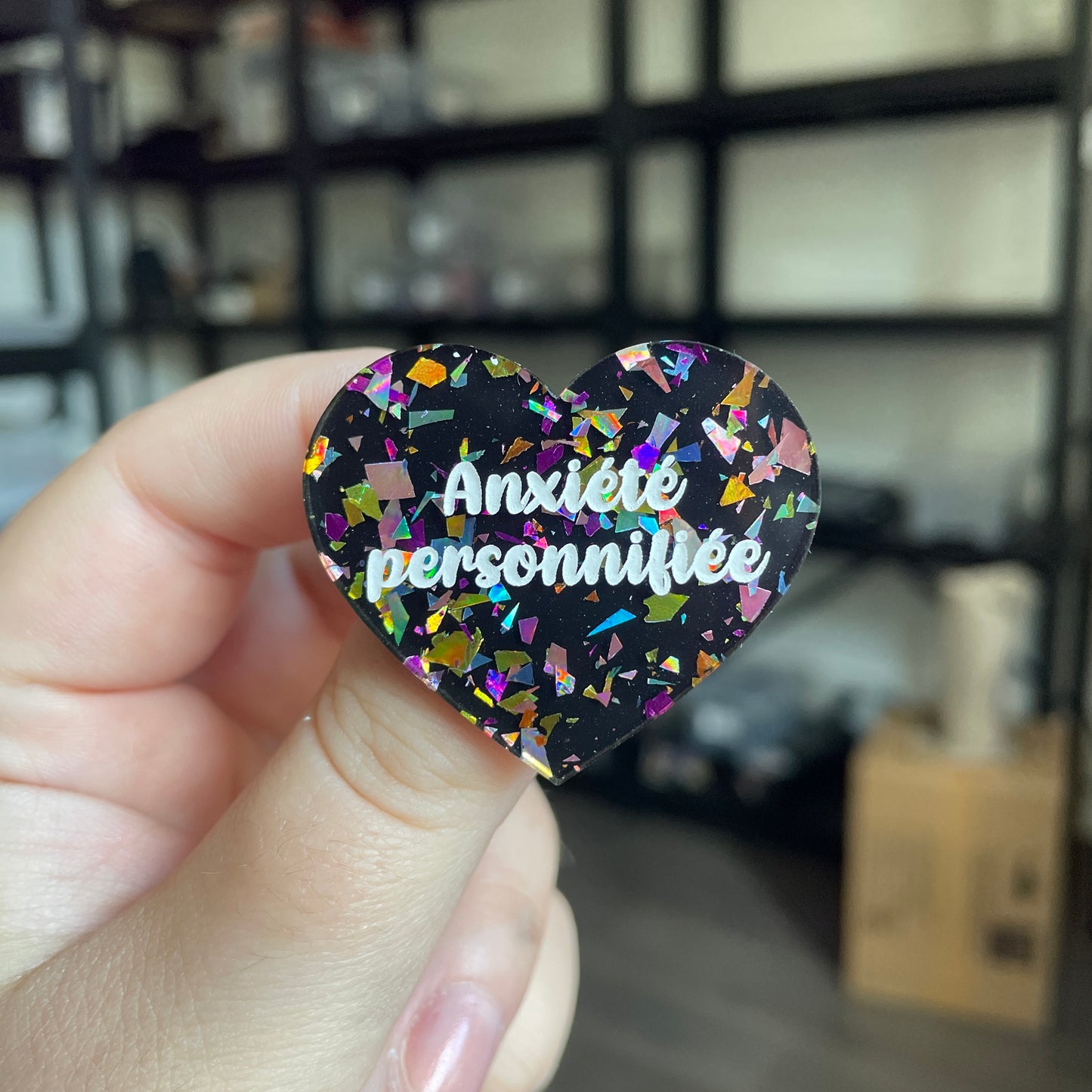 Broche "Anxiété personnifiée" en acrylique noire avec des éclats de confettis multicolores