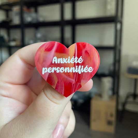 Broche "Anxiété personnifiée" en acrylique marbrée rouge, blanche et dorée