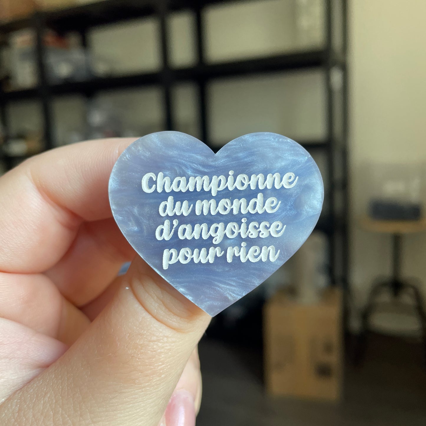 Broche "Championne du monde d'angoisse pour rien" en acrylique marbrée bleue/grise