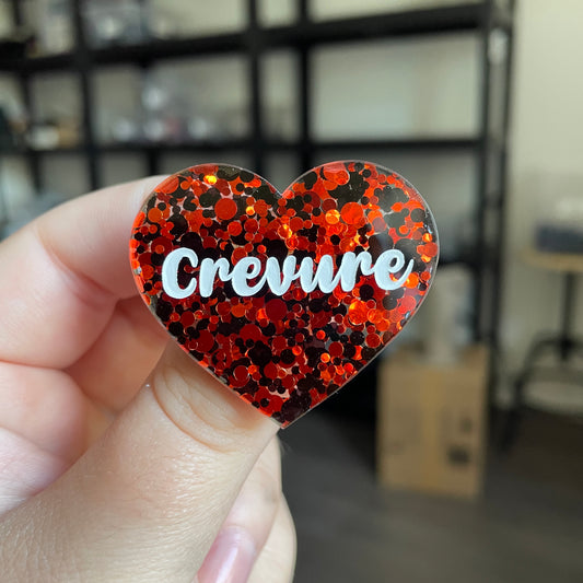 Broche "Crevure" en acrylique semi transparente avec des pois rouges et noirs