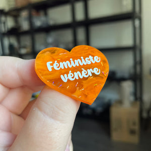 Broche "Féministe vénère" en acrylique japonaise semi transparente orange avec des confettis