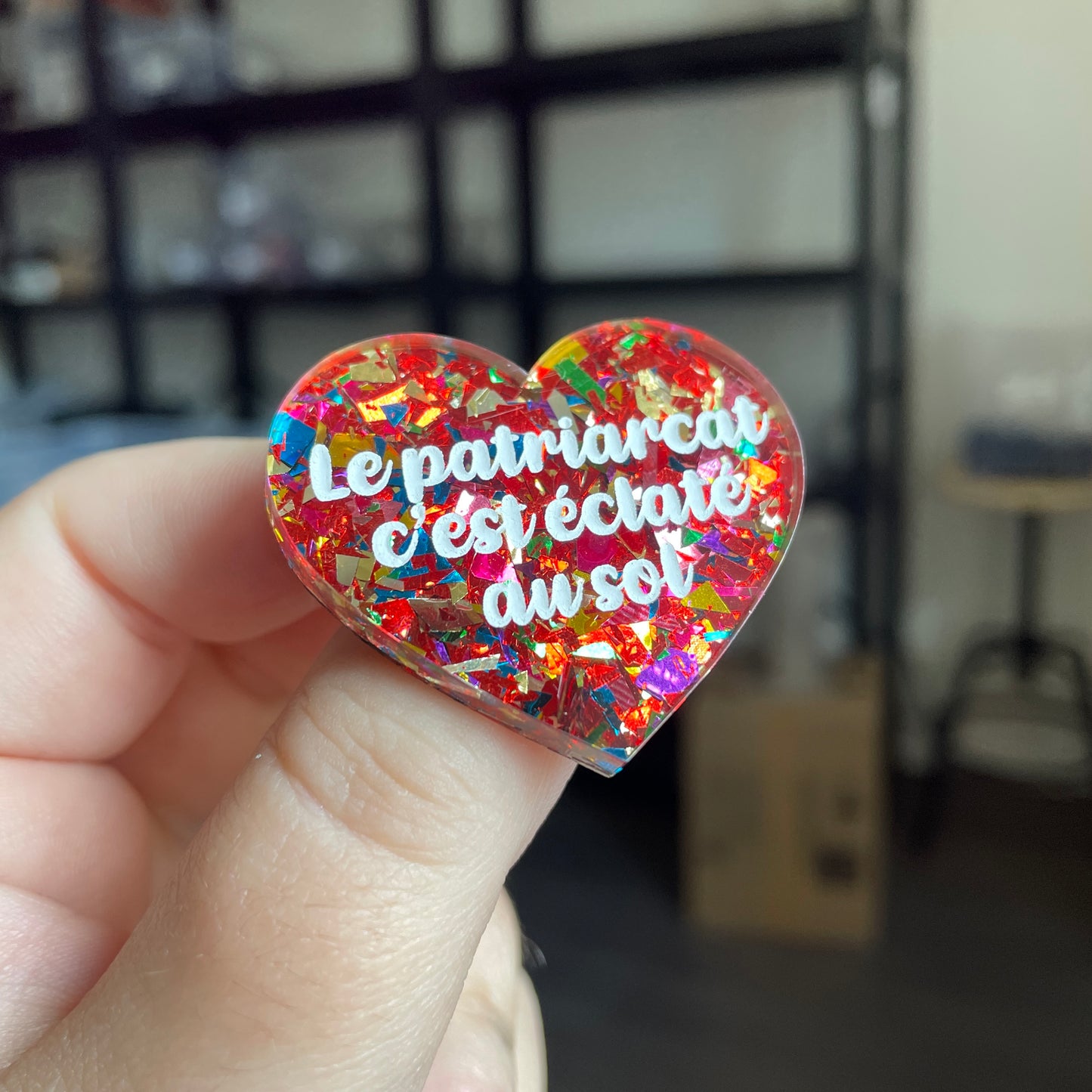 Broche "Le patriarcat c'est éclaté au sol" en acrylique transparente avec des éclats de confettis rouges et multicolores