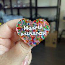 Charger l&#39;image dans la galerie, Broche &quot;Nique le patriarcat&quot; en acrylique semi transparente avec des confettis étoiles multicolores