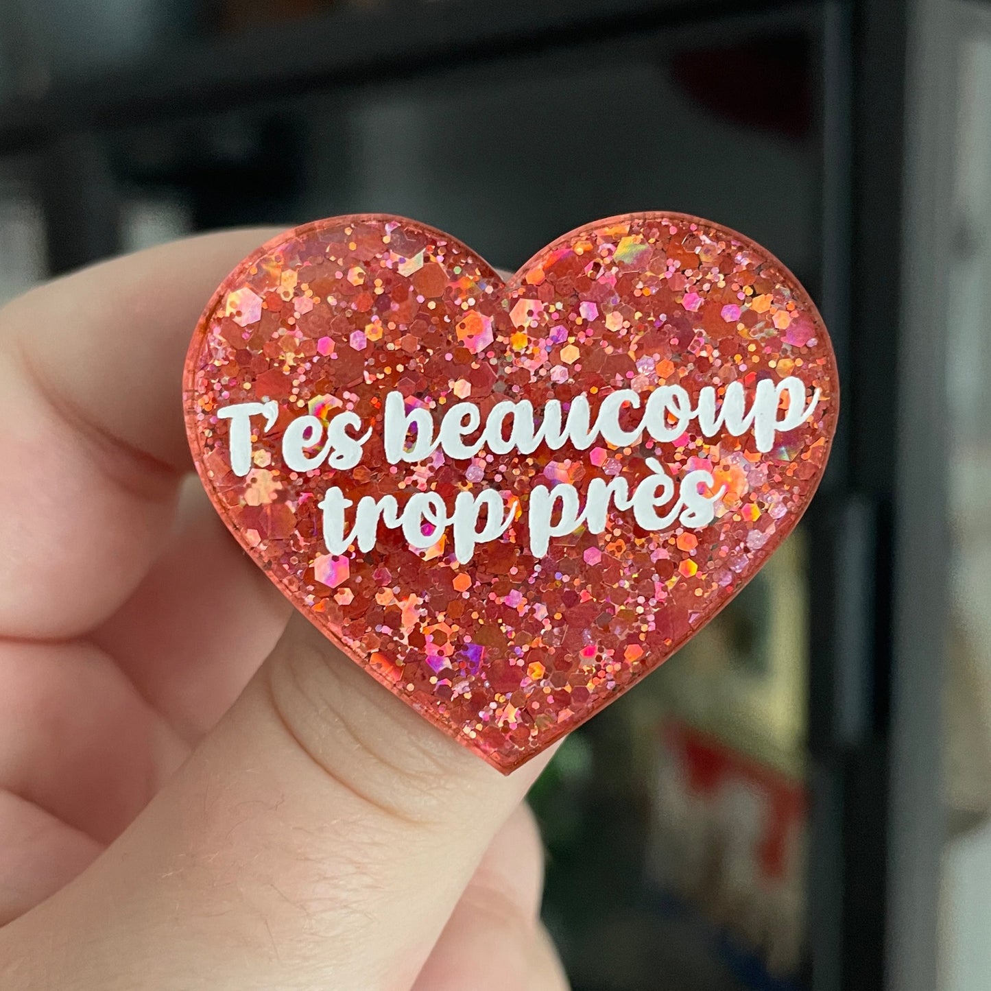 Broche "T'es beaucoup trop près" en acrylique à paillettes roses/corail