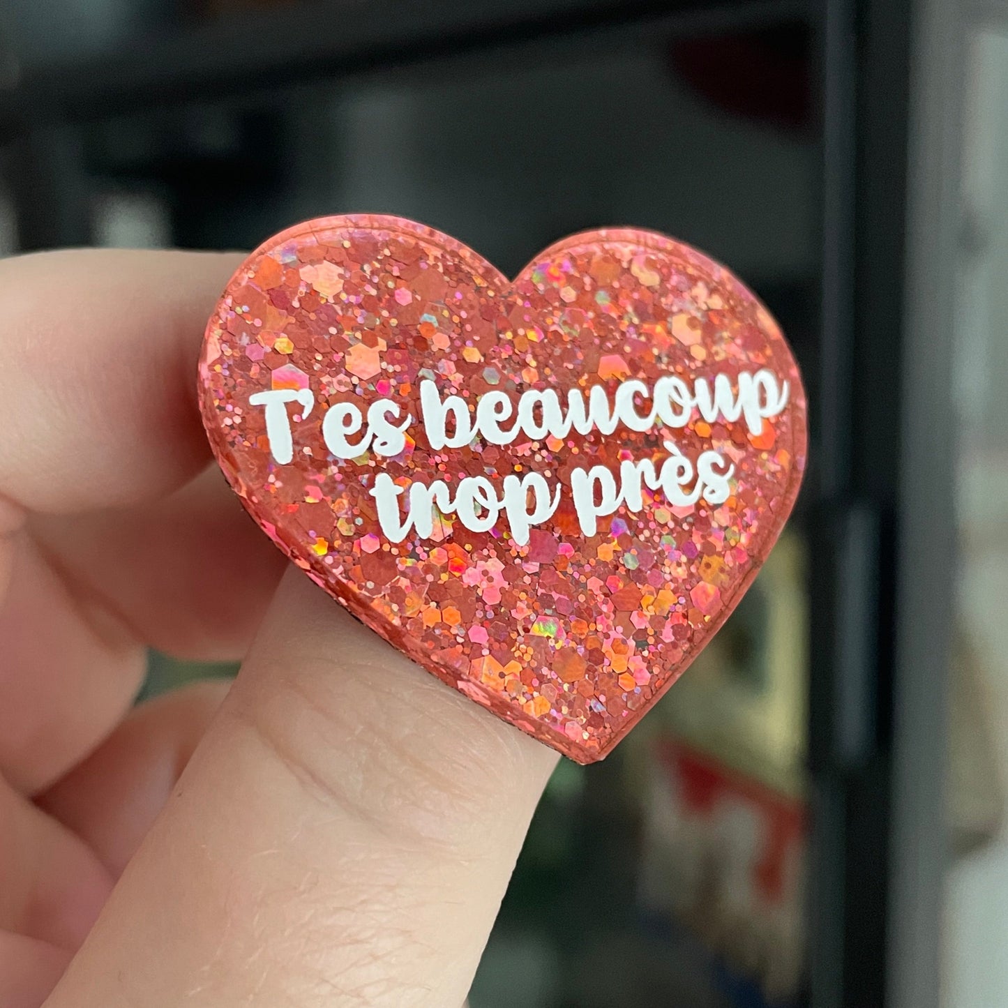 Broche "T'es beaucoup trop près" en acrylique à paillettes roses/corail