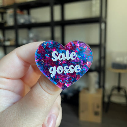 Broche "Sale gosse" en acrylique transparente avec des éclats de confettis bleus et violets/roses