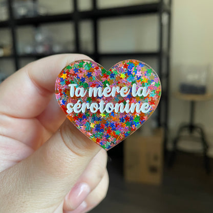 Broche "Ta mère la sérotonine" en acrylique semi transparente avec des confettis étoiles multicolores