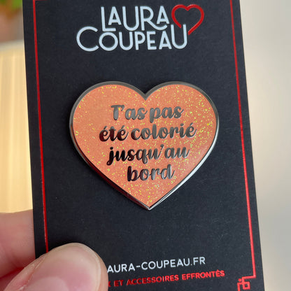 Pin en émail "T'as pas été colorié jusqu'au bord" orange à paillettes