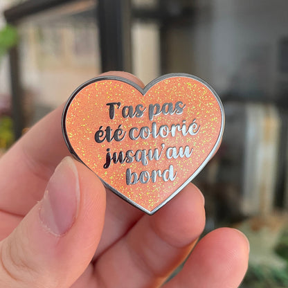 Pin en émail "T'as pas été colorié jusqu'au bord" orange à paillettes