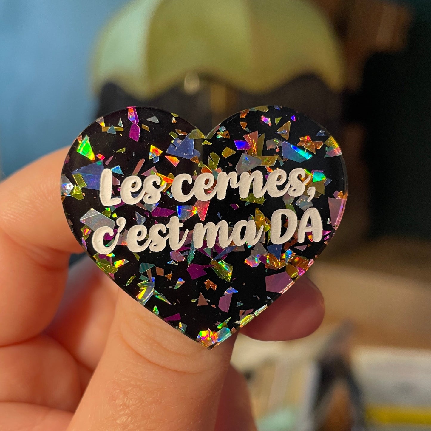 [Contrôle technique] Broche "Les cernes, c'est ma DA" en acrylique noire avec des éclats de confettis multicolores