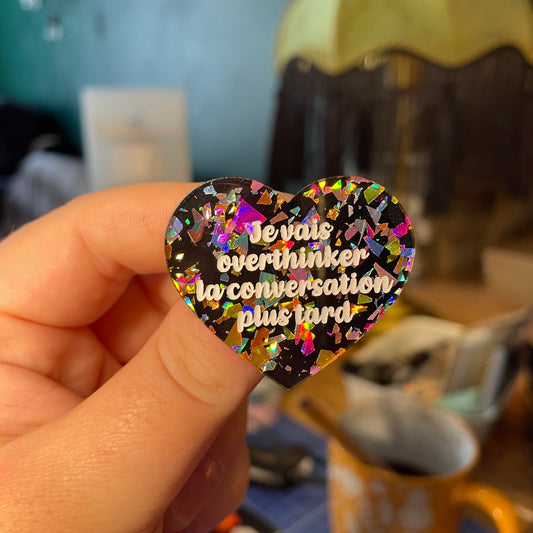 [Contrôle technique] Broche "Je vais overthinker la conversation plus tard" en acrylique noire avec des éclats de confettis multicolores