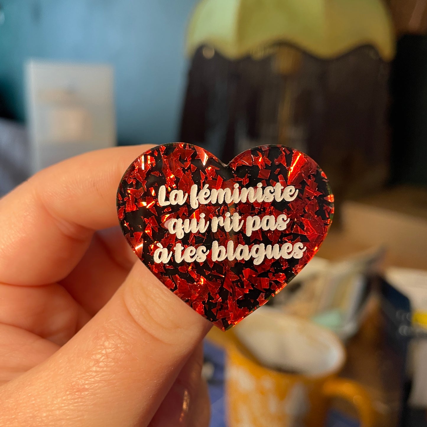 [Contrôle technique] Broche "La féministe qui rit pas à tes blagues" en acrylique noire avec des éclats de confettis rouges