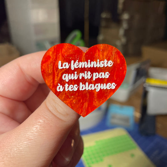 [Contrôle technique] Broche "La féministe qui rit pas à tes blagues" en acrylique marbrée orange à paillettes