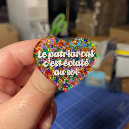 [Contrôle technique] Broche "Le patriarcat c'est éclaté au sol" en acrylique transparente avec des étoiles multicolores