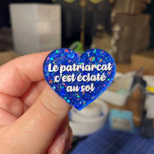 [Contrôle technique] Broche "Le patriarcat c'est éclaté au sol" en acrylique à paillettes bleues