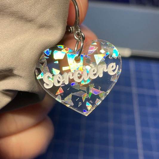 [A l'unité] Petites boucle d'oreille coeur pendante "Sorcière" en acrylique transparente avec des éclats de confettis argentés
