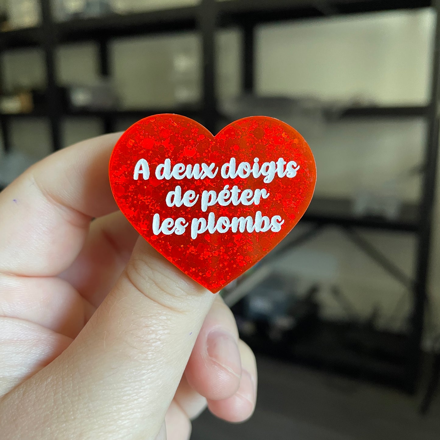 Broche "A deux doigts de péter les plombs" en acrylique à paillettes rouges/oranges