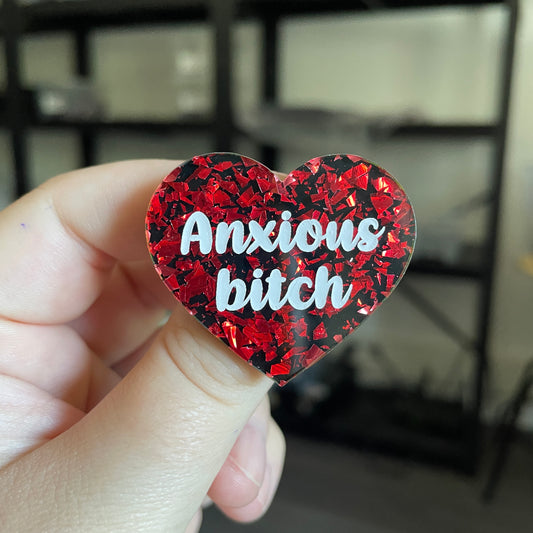 Broche "Anxious bitch" en acrylique noire avec des éclats de confettis rouges