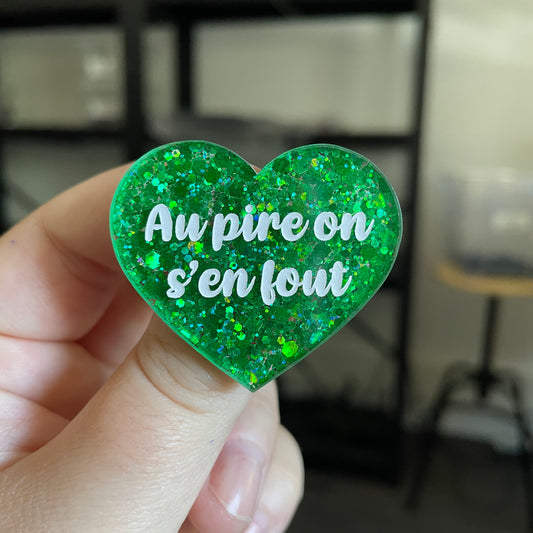 Broche "Au pire on s'en fout" en acrylique semi transparente à paillettes vertes