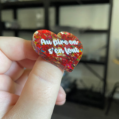 Broche "Au pire on s'en fout" en acrylique transparente avec des confettis rouges et multicolores